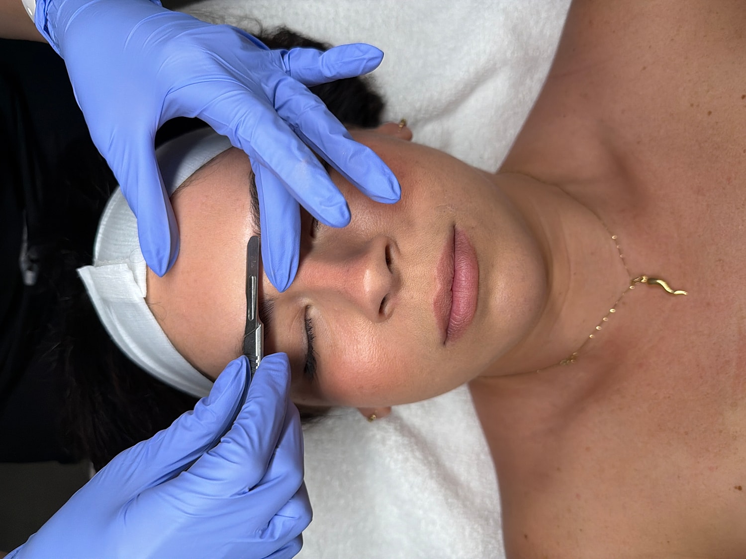 Woman receiving eyebrow shaping treatment.