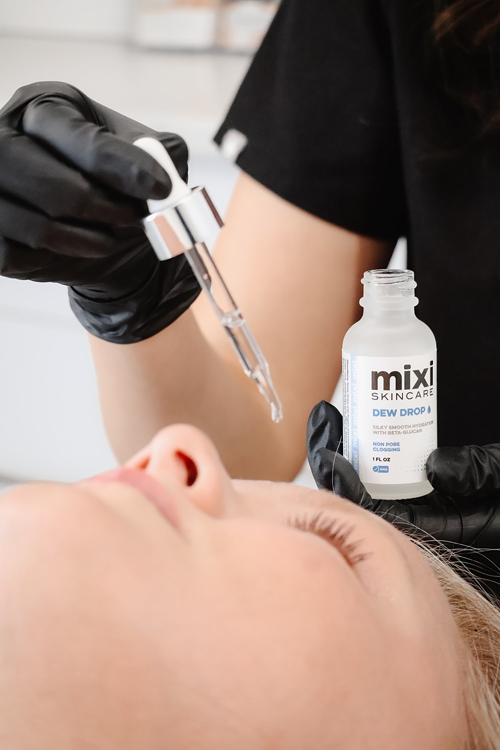 Applying serum to a client's face during treatment