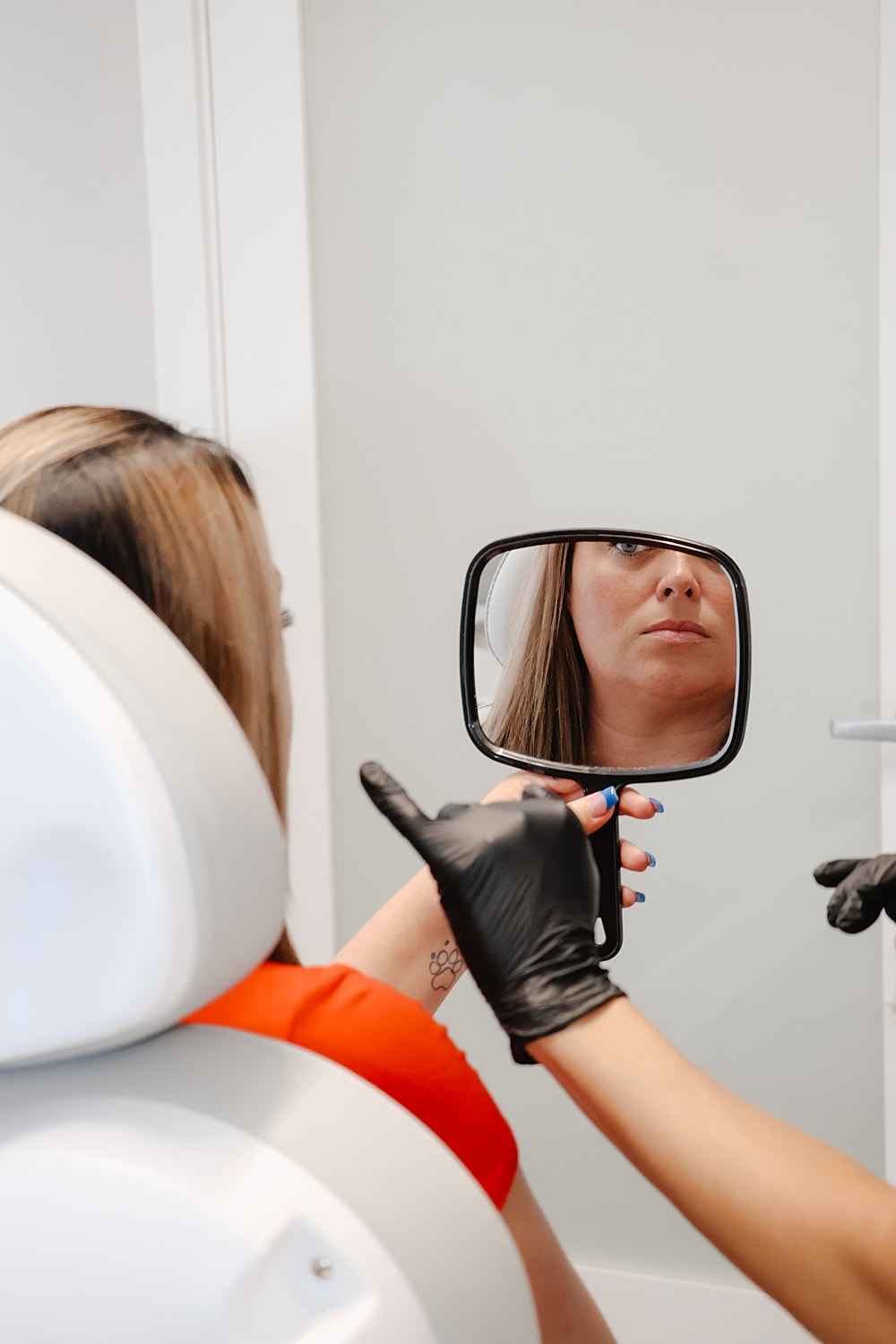 Client examines reflection during beauty treatment session.