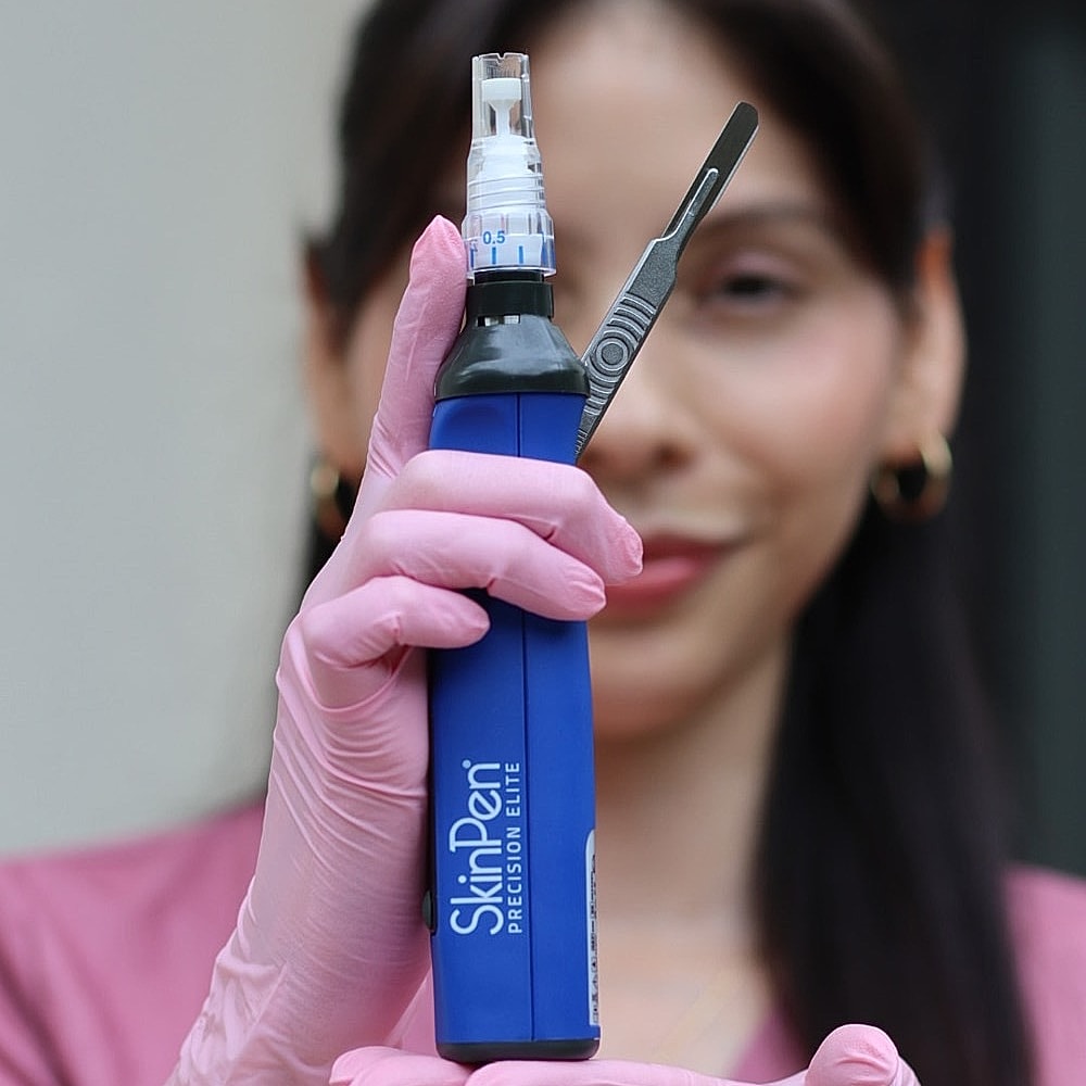 SkinPen device held by gloved professional.